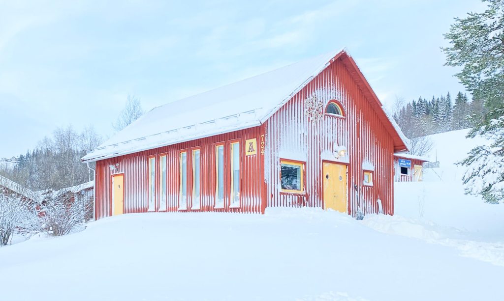 Ateljé Ave Saltus vinterbild. Ett rött hus där all formgivning sker och grafiska original framställs.